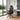 Black office chair with headrest in a modern room with large windows and a desk.