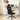 Black office chair in front of a wooden desk with a laptop and decor items.